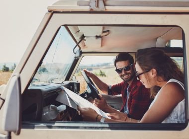 Man and woman preparing to drive through mountains.