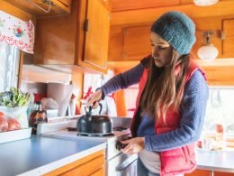 Woman preparing tea in her camper.