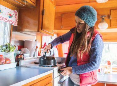 Woman preparing tea in her camper.