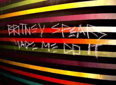 Graffiti in Arizona that reads "Britney Spears Made Me Do It" on a colorful striped wall.