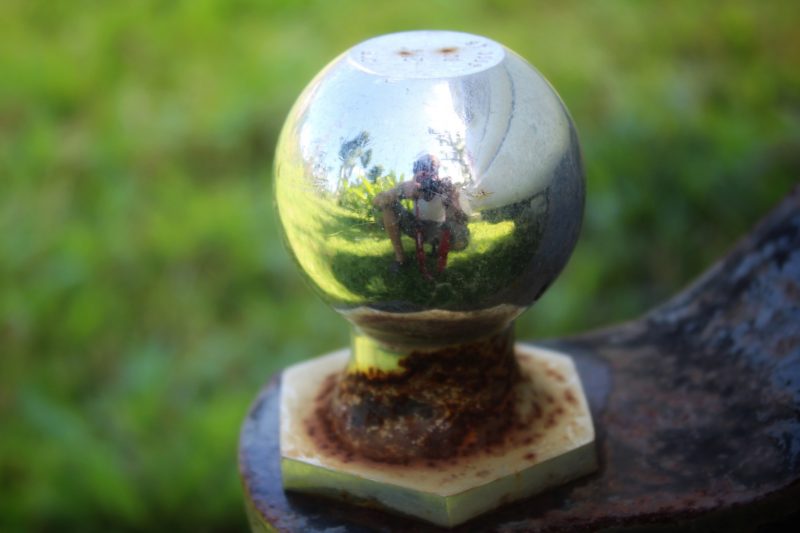 Close up of a weather hitch ball reflecting camera man in metal.