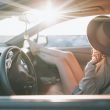 A woman sitting in the passenger seat of a car at golden hour.