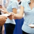 A woman hands a brochure to a customer at an RV show