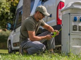 Man inspects the electric plug connection for his RV.