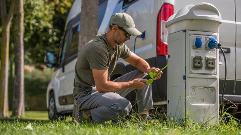 Man inspects the electric plug connection for his RV.