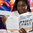 A woman reads a book on how to make a profit.