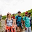 A group of friends hiking on a crowded trail in the mountains.