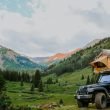 A Jeep with a topper tent in the mountain wilderness.