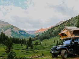 A Jeep with a topper tent in the mountain wilderness.