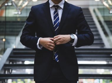 A business man wearing a suit from the neck down.