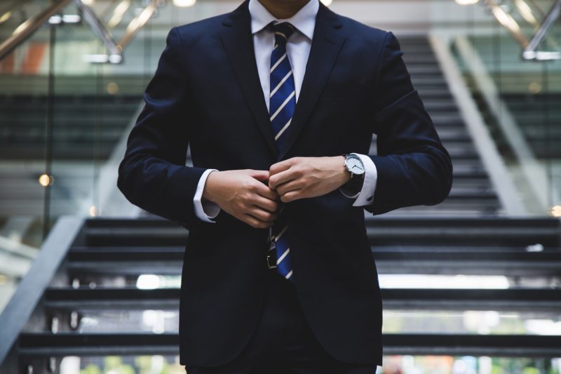 A business man wearing a suit from the neck down.