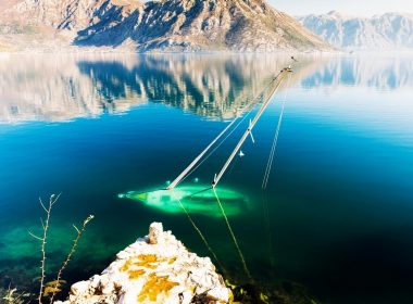 A sailboat sitting at the bottom of lake.