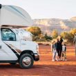 A family takes a photo outside of their Class C Motorhome