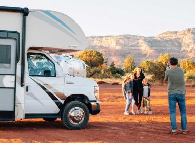 A family takes a photo outside of their Class C Motorhome