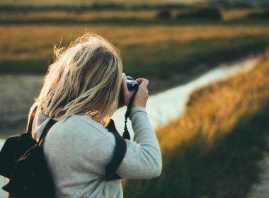 A nature photographer captures a landscape at dusk.