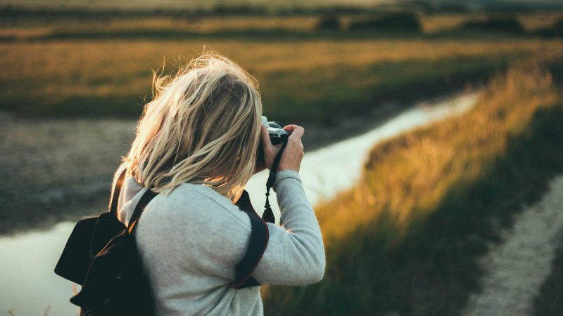 A nature photographer captures a landscape at dusk.