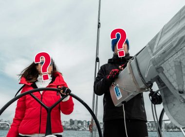 Two unidentified sailors on a sailboat at sea.