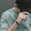 A man covers his eyes with the brim of his black ball cap.