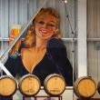 A huge signn of a woman from the 1960's drinking a beer out of a glass in a brewery
