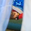 A young child sleeping on an air mattress while on a camping trip
