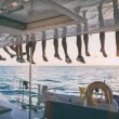 Sundown on a sailing yacht with the crew's legs dangling over the roof to enjoy the view.
