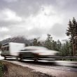 Caravan car travels on the highway at high speed on wet pavement.