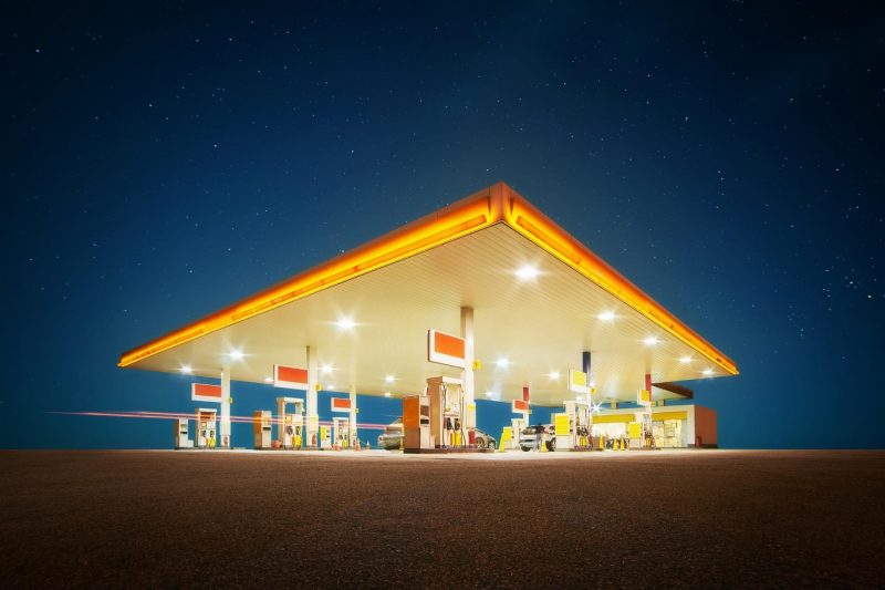 A gas station lit up at night against a starry sky.