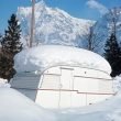 A travel trailer snowed in with a foot of accumulation on the top in the mountains.