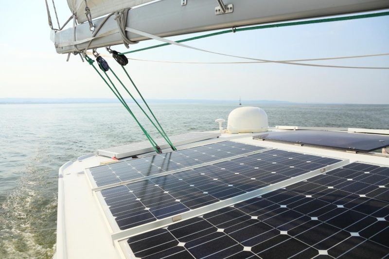 Solar Panels charging batteries aboard sail boat on the water.