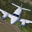 A King Air airplane flying above an airport.