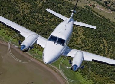 A King Air airplane flying above an airport.