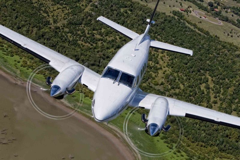 A King Air airplane flying above an airport.