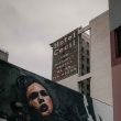 Looking up at the old painted sign for Hotel Cecil in downtown Los Angeles on a cloudy day.