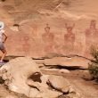 A tourist stands to admire the petroglyphs at Sego Canyon but it has been vandalized.