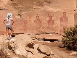 A tourist stands to admire the petroglyphs at Sego Canyon but it has been vandalized.
