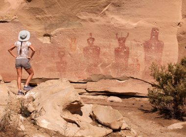 A tourist stands to admire the petroglyphs at Sego Canyon but it has been vandalized.