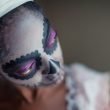 A woman wearing voodoo makeup.