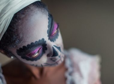 A woman wearing voodoo makeup.
