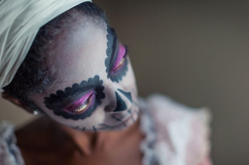 A woman wearing voodoo makeup.