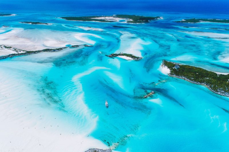 From high above, turquoise blue waters shine brilliantly in the sun along the Exuma Islands in the Bahama.