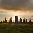 Sunrise behind ancient stone erected in a circle.