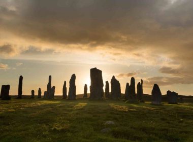 Sunrise behind ancient stone erected in a circle.