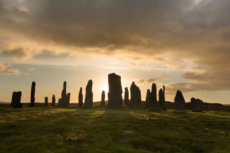 Sunrise behind ancient stone erected in a circle.
