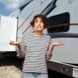 Unsure in front of the decals on an RV in a parking lot.