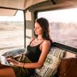 Woman in the back of a camper van using her laptop.