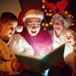 Grandparents and grandkids enjoying the magic of Christmas as they read a book together.