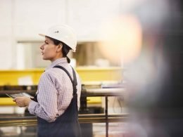 Assembly line worker on the manufacturing floor looking for someone.