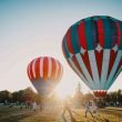 Two hot air balloons getting ready for a sunrise flight at a festival.