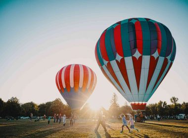 Two hot air balloons getting ready for a sunrise flight at a festival.