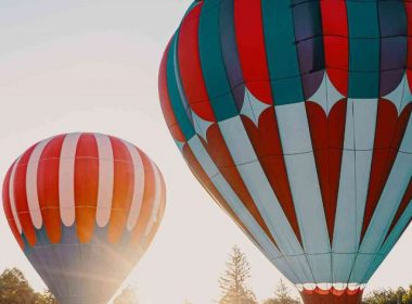 Two hot air balloons getting ready for a sunrise flight at a festival.